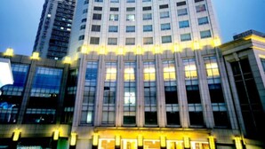 Un edificio de varios pisos con un diseño arquitectónico moderno, caracterizado por una serie de columnas verticales y amplias ventanas.