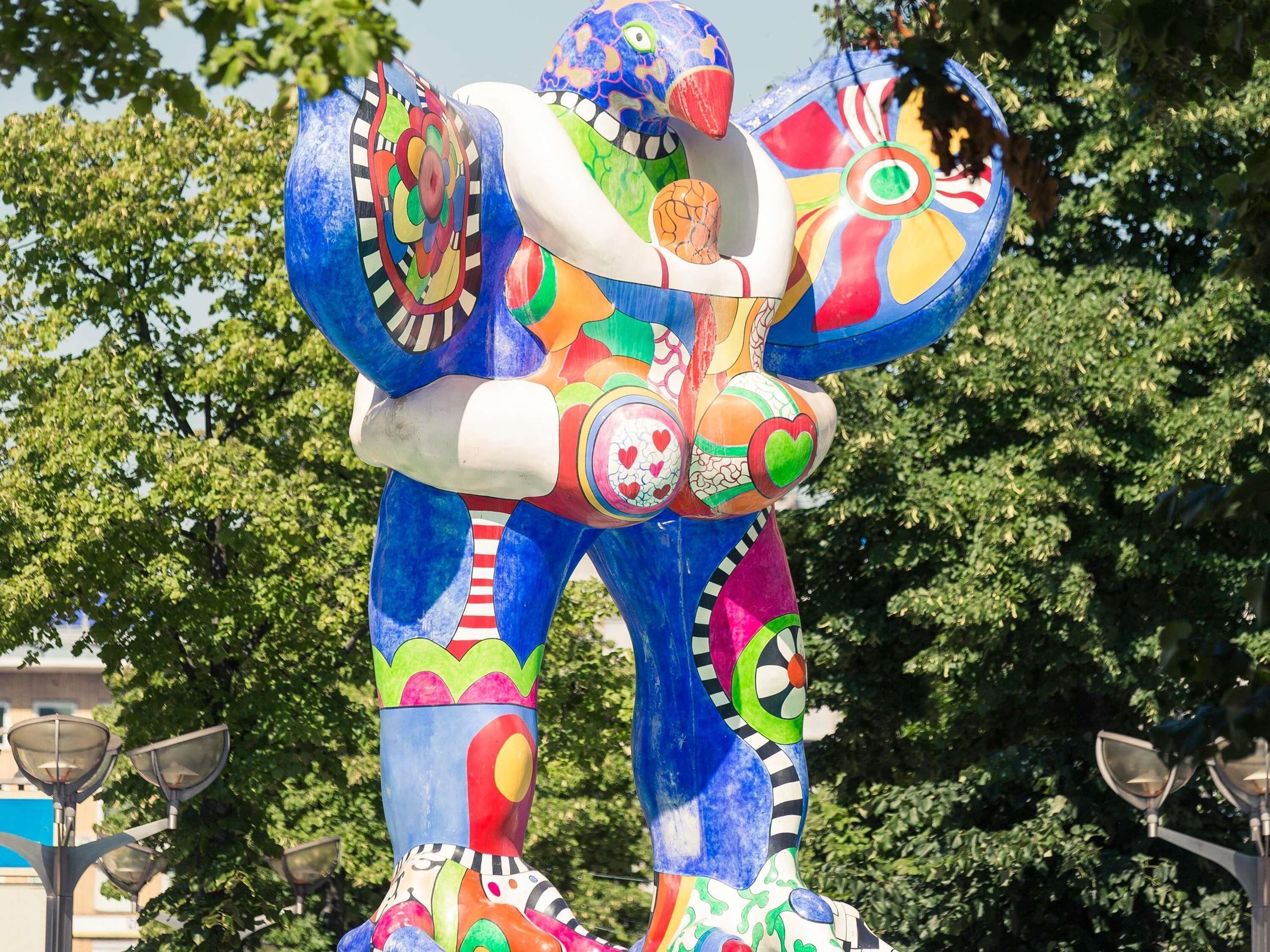 Una escultura colorida de una figura con patrones y formas abstractas.