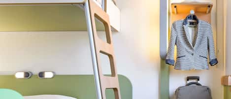 A bunk bed with a green headboard, a bedside table with a book and pen, a suitcase, and a hanging coat rack with a striped jacket.