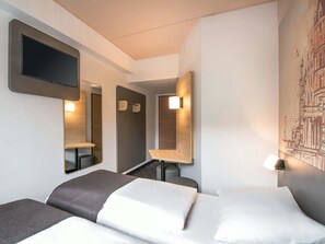 A hotel room with two beds, a flat-screen TV, a mirror, and a wall-mounted light fixture. - B&B HOTEL Schwerin-Süd (Schwerin)