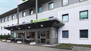 Un hotel B&B con fachada moderna, zona de estar al aire libre y una entrada acogedora.
