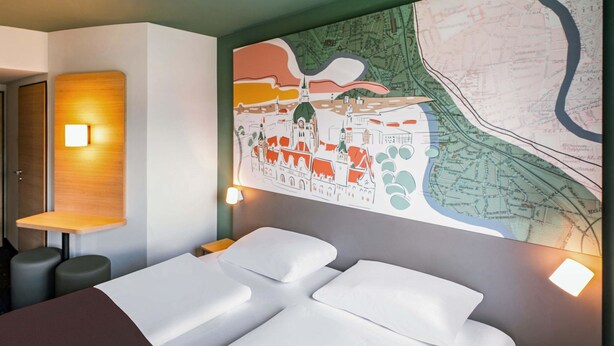 Una habitación de hotel con una cama grande, un mapa en la pared y un cabecero de madera.