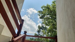 Una escalera de madera con vistas a un cielo despejado y frondosos árboles verdes.