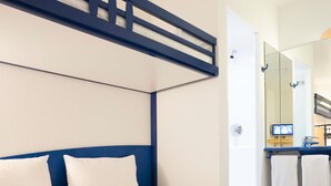 A hotel room with a bed, a headboard, a mirror, a sink, and a towel rack. - Ibis Budget Hannover Hauptbahnhof (Hannover)