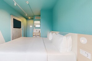 A hotel room with a bed, a bedside table, a mirror, and a window. - Ibis Express Hannover Central Station (Hannover)
