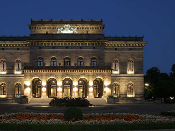 A large, historic building with a central entrance, arched windows, and a statue on the roof. - Ibis Express Hannover Central Station (Hannover)