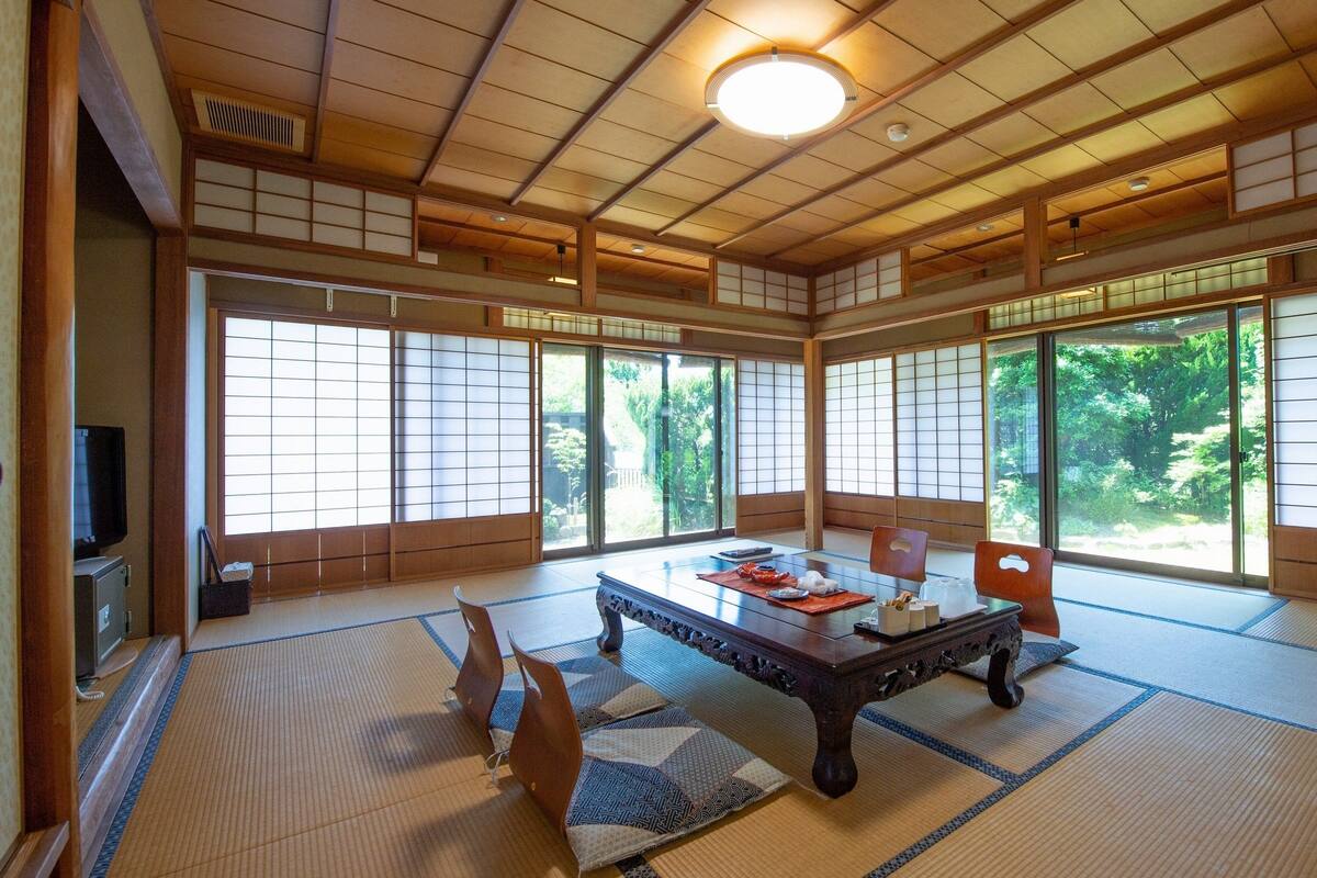 Habitació japonesa tradicional amb fons de tatami, una taula baixa i portes corredisses.