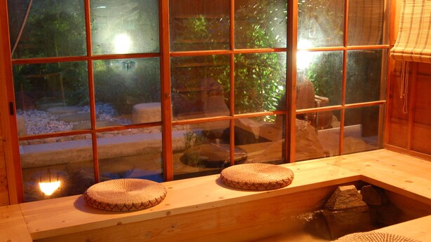 A traditional Japanese room with tatami mats, a wooden bench, and a view through large glass windows. - Yuhigaura Onsen Konoya (Kyotango)