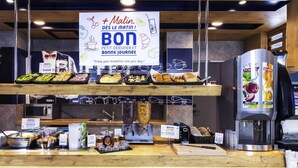 A breakfast buffet with various food items and a coffee machine.