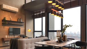 A modern dining area with a large window, a sofa, and a dining table with chairs. - Expressionz Professional Suites by Luxurious Lifestyle Living (Kuala Lumpur)