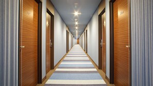 A hotel hallway with doors numbered 507 and 508, featuring a striped carpet and recessed lighting.