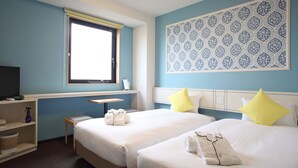 A hotel room with two beds, a desk, a TV, and a window.