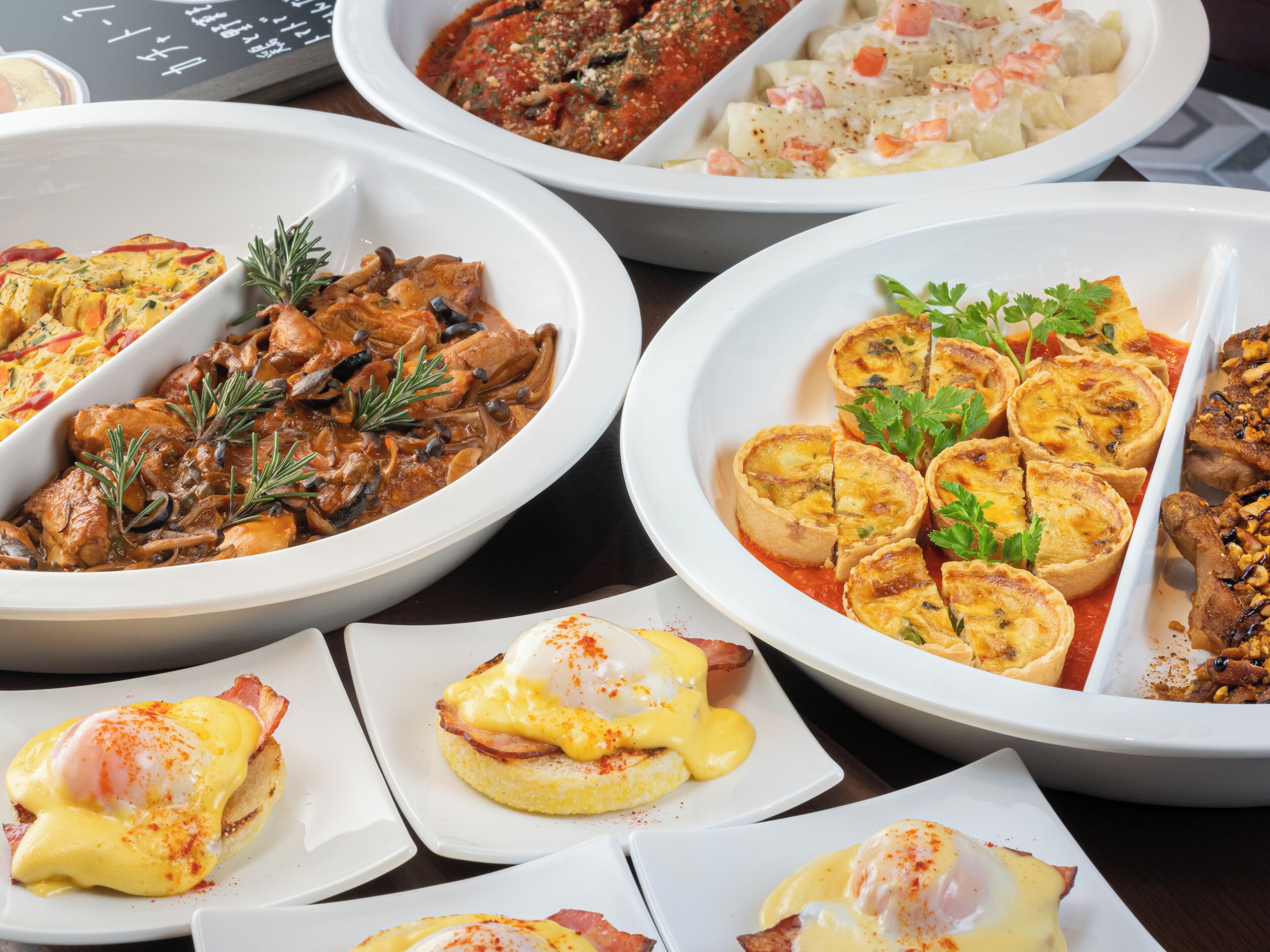 A variety of dishes including quiches, a poached egg, and a seafood dish, suggesting a diverse menu.