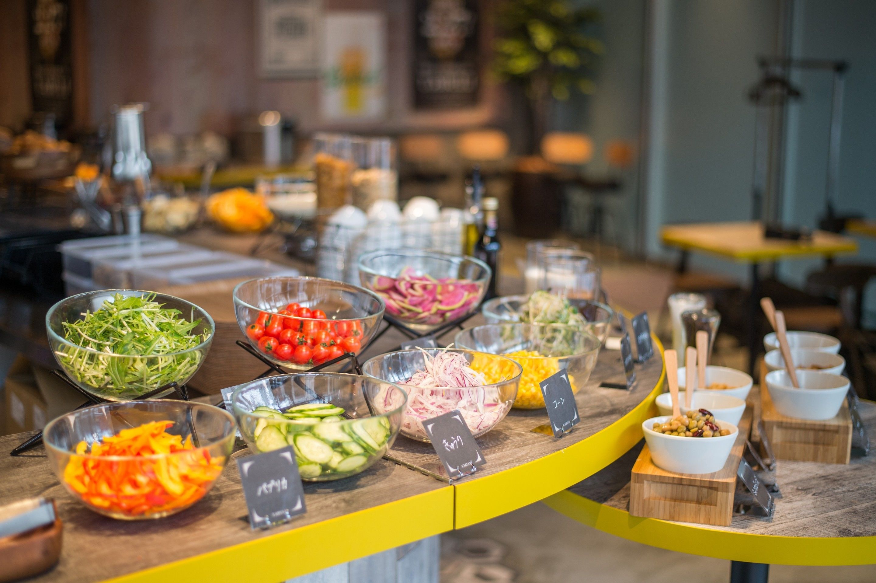 Un bufé con diversos alimentos, entre ellos ensaladas, verduras y frutas.