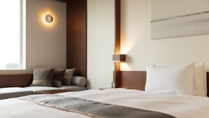 A hotel room with two beds, a nightstand, a wall-mounted light, and a window. - Tokyu Stay Fukuoka Tenjin (Fukuoka)