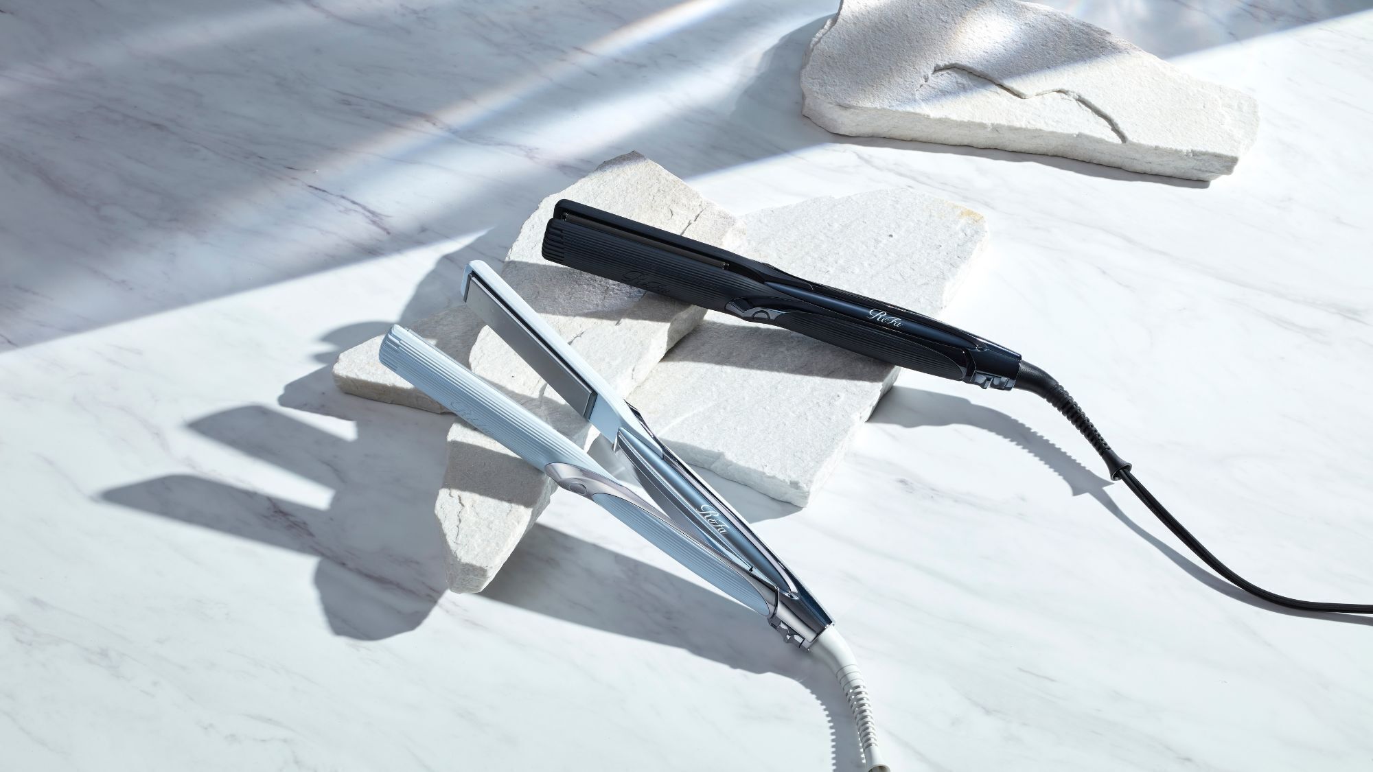A pair of scissors and a razor blade on a marble surface.