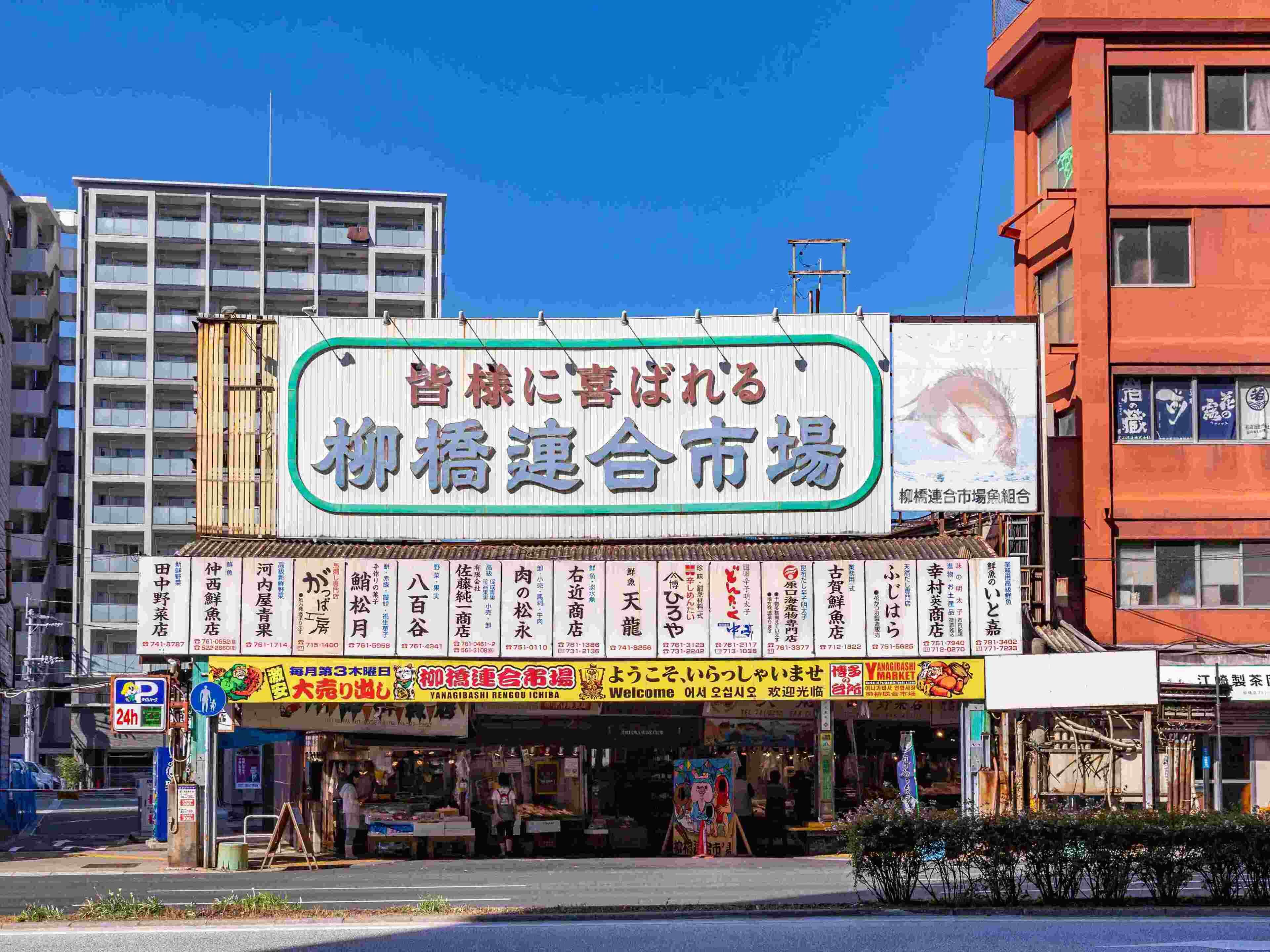 Un edificio comercial con varias tiendas y un gran cartel publicitario de un mercado.