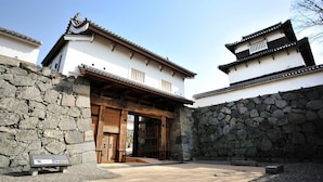 A traditional Japanese building with a stone wall entrance, wooden doors, and a tiled roof. - Tokyu Stay Fukuoka Tenjin (Fukuoka)