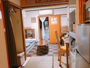 Ein kompakter Wohnbereich mit Küchenzeile, Essbereich und einem kleinen Schlafzimmer.