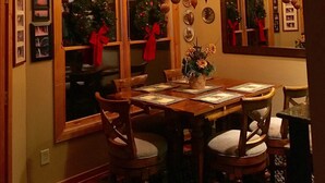A dining room with a wooden table, chairs, a chandelier, and Christmas decorations. - HEAVEN'S PEAK - Luxurious, mountain top retreat; 5 Star  (Ranger)