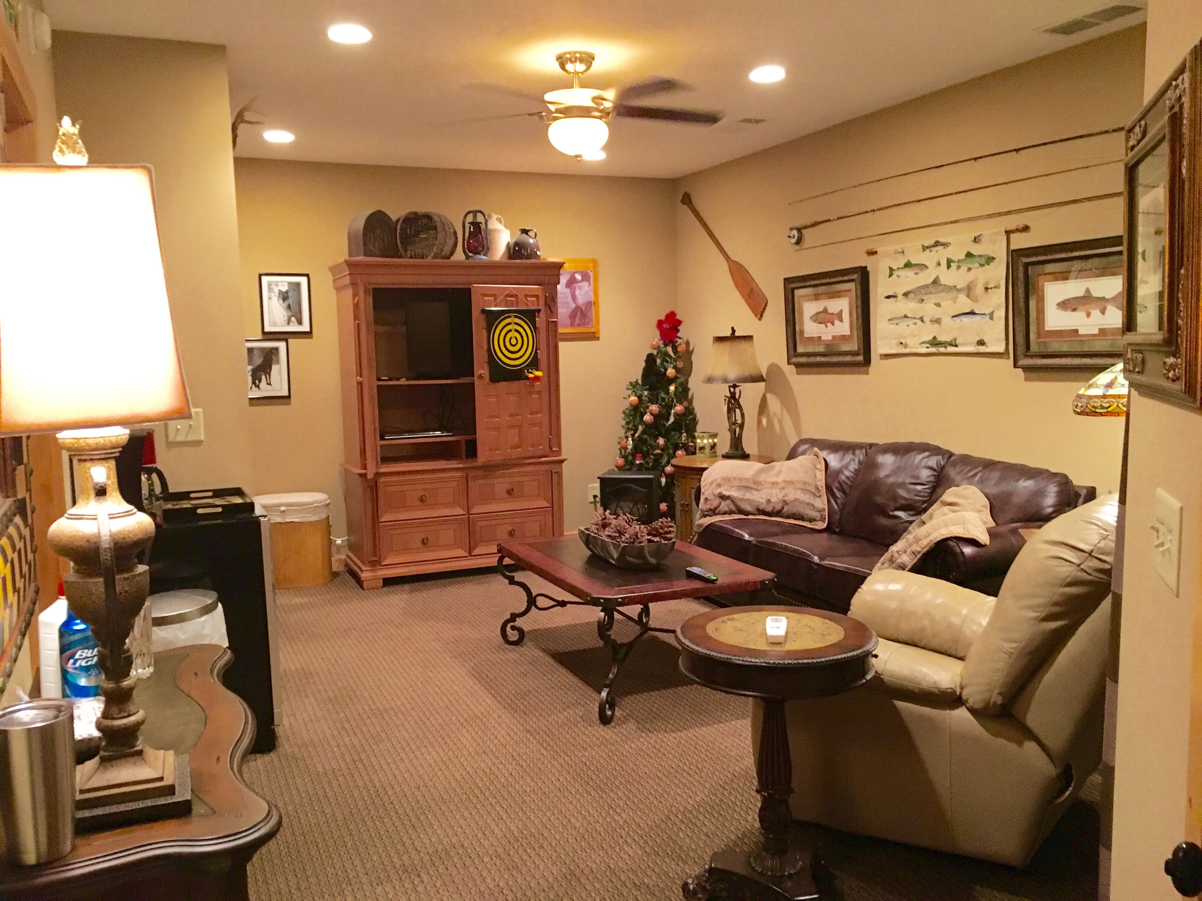 A cozy living room with a leather sofa, a coffee table, a fireplace, and a Christmas tree.