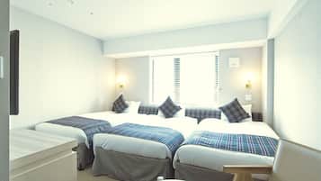 Ett hotellrum med två sängar, ett skrivbord och en stol.