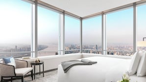 A modern hotel room with a large bed, a seating area, and a view of a cityscape through large windows. - Niccolo Changsha (Changsha)