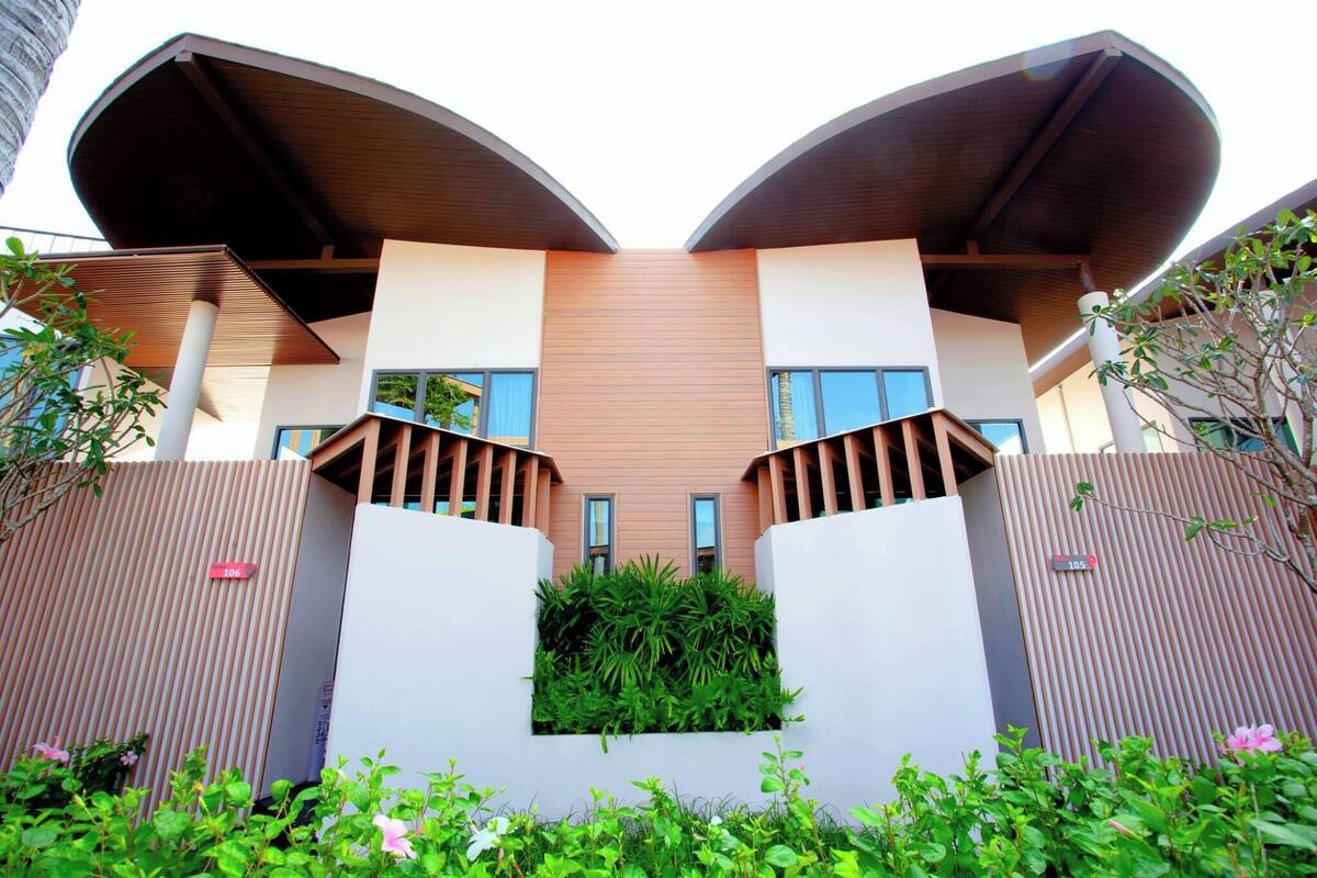 Un edificio moderno con un diseño arquitectónico único que presenta dos grandes estructuras curvas en el techo.