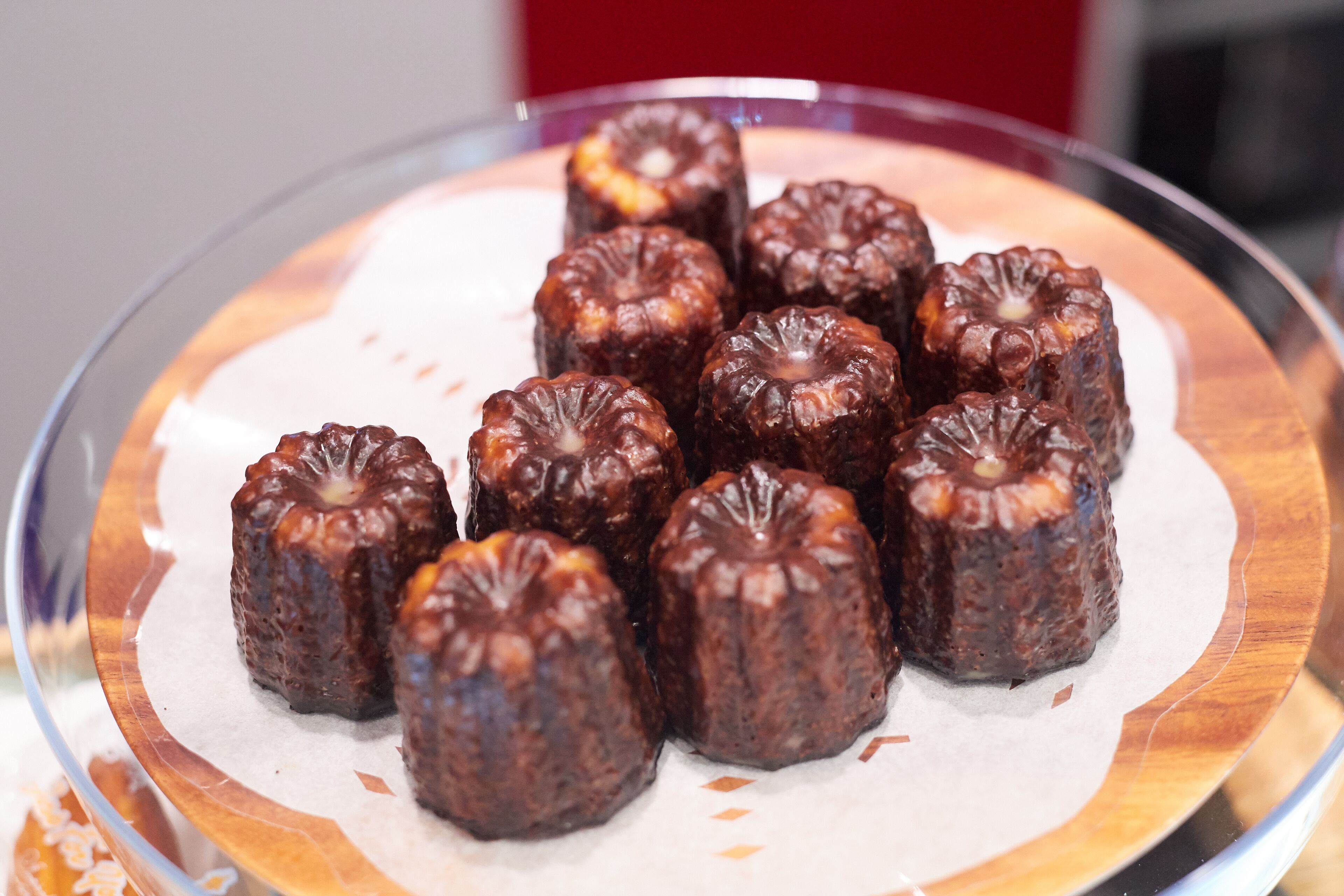 A glass plate with several chocolate-covered pastries on a white paper.