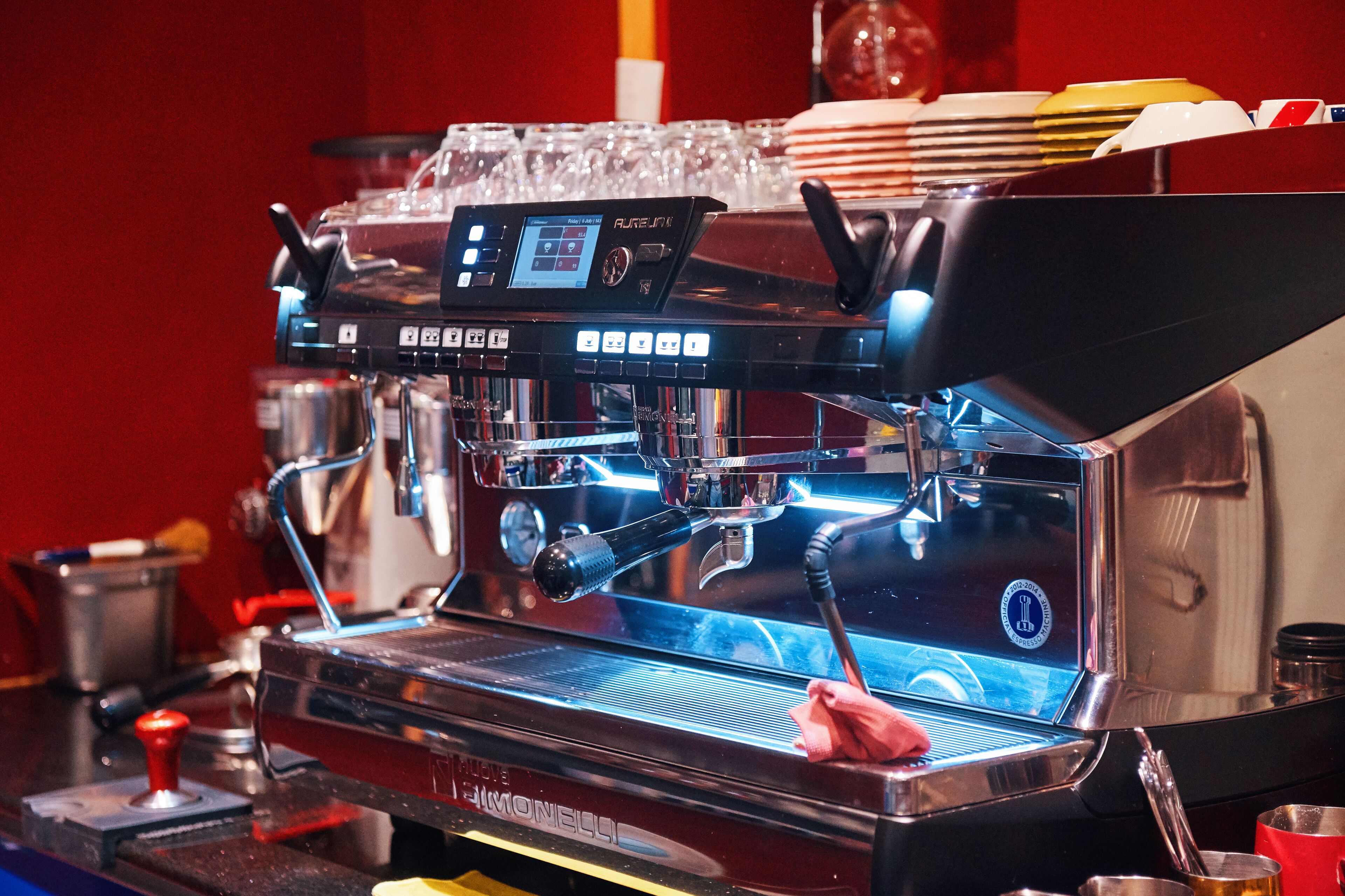 Une machine à expresso professionnelle dotée d’un écran numérique et de plusieurs boutons de commande.