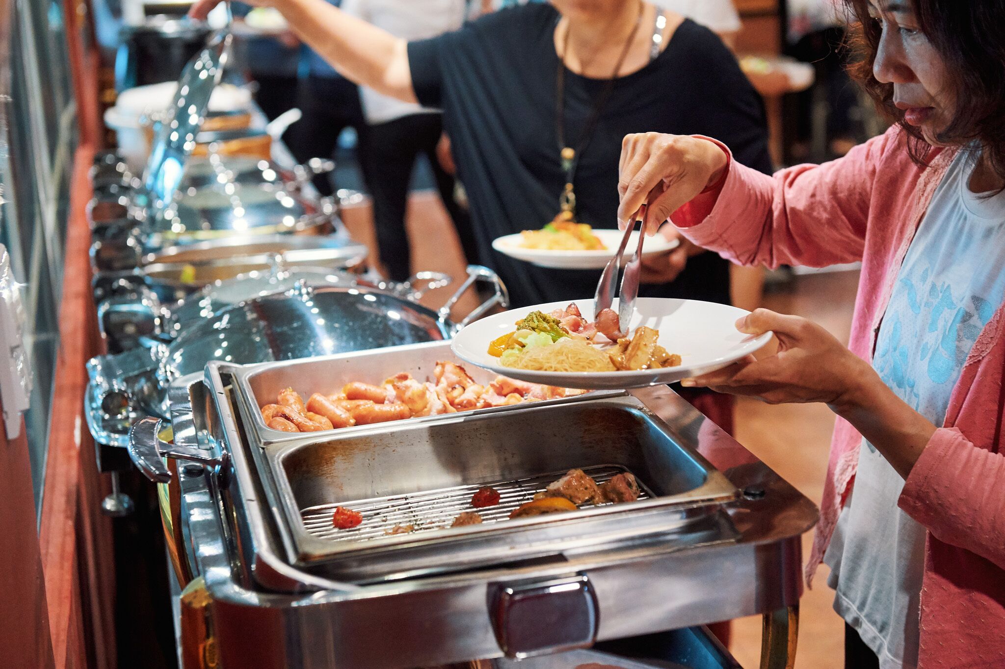 Una barra de buffet con diversas opciones de comida, incluyendo mariscos y pasta.