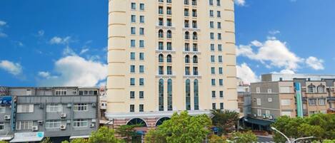 Un hotel de varios pisos con un atrio central, rodeado de otros edificios.