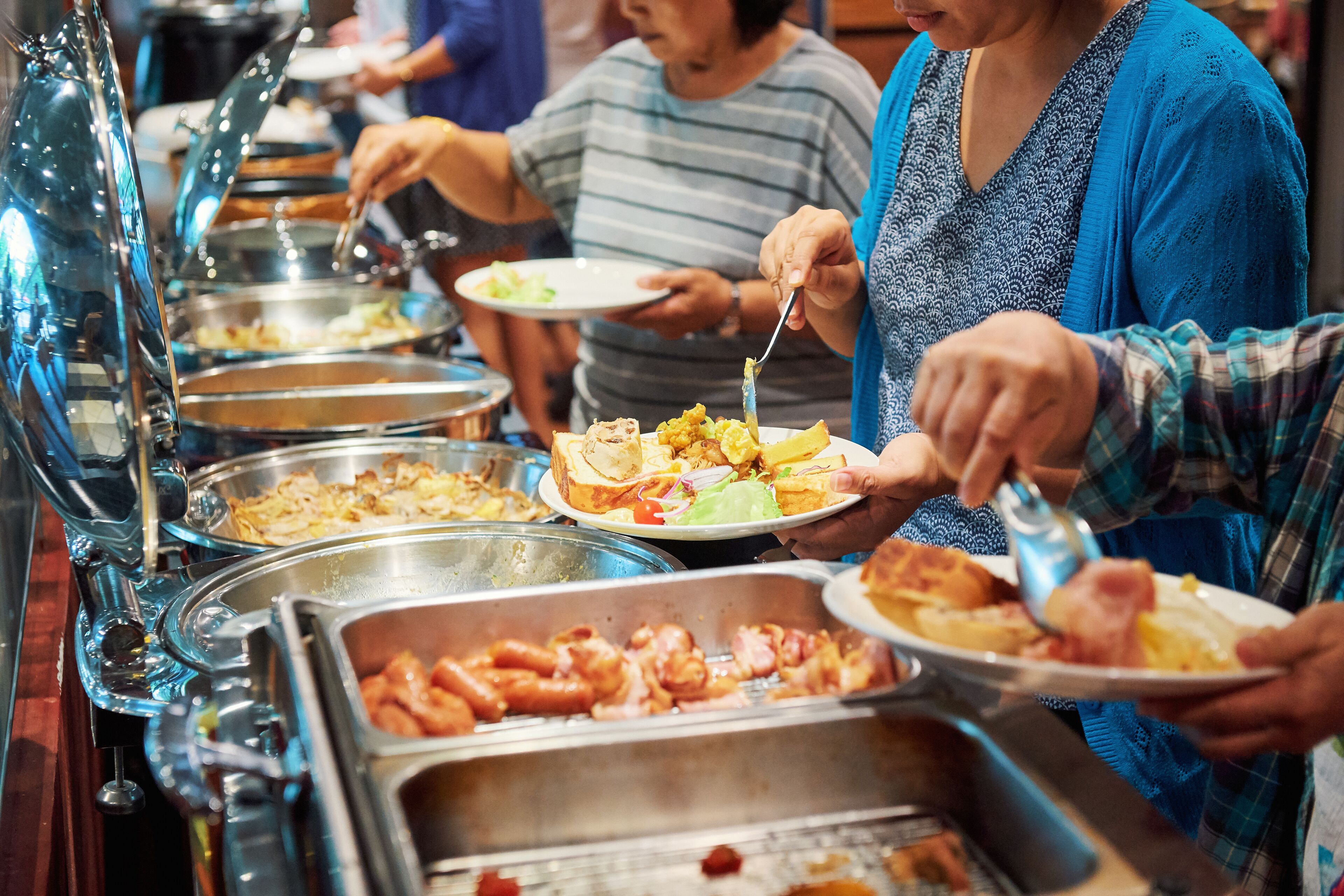 A buffet with various food options, including meats and salads.