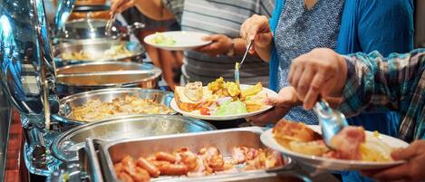 A buffet with various food options, including meats and salads.