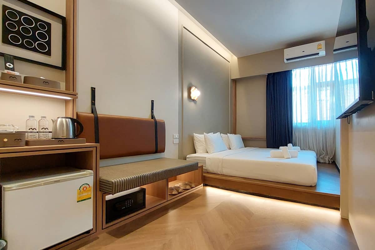Ein Hotelzimmer mit einem Bett, einem Schreibtisch mit Wasserkocher, Mikrowelle und Kühlschrank.