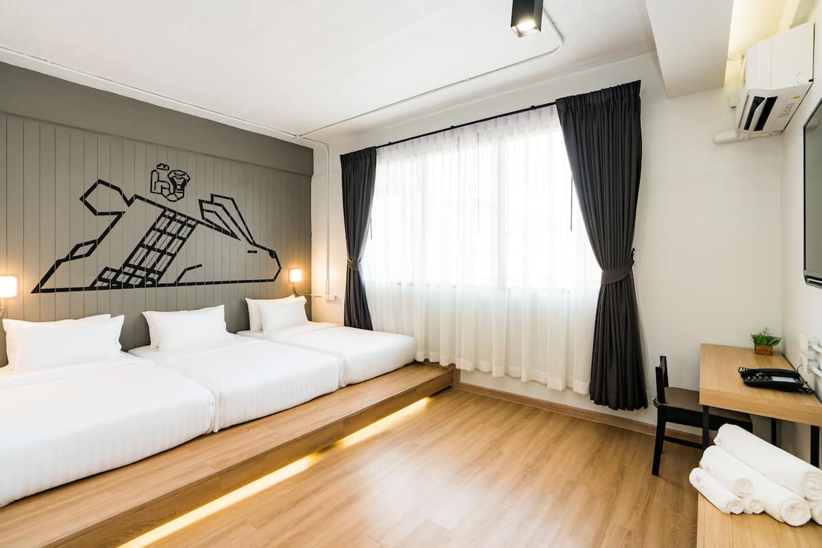 Ein modernes Hotelzimmer mit einem großen Bett, einem Schreibtisch und einem Fernseher.