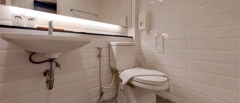 A bathroom with a white sink, toilet, and shower.