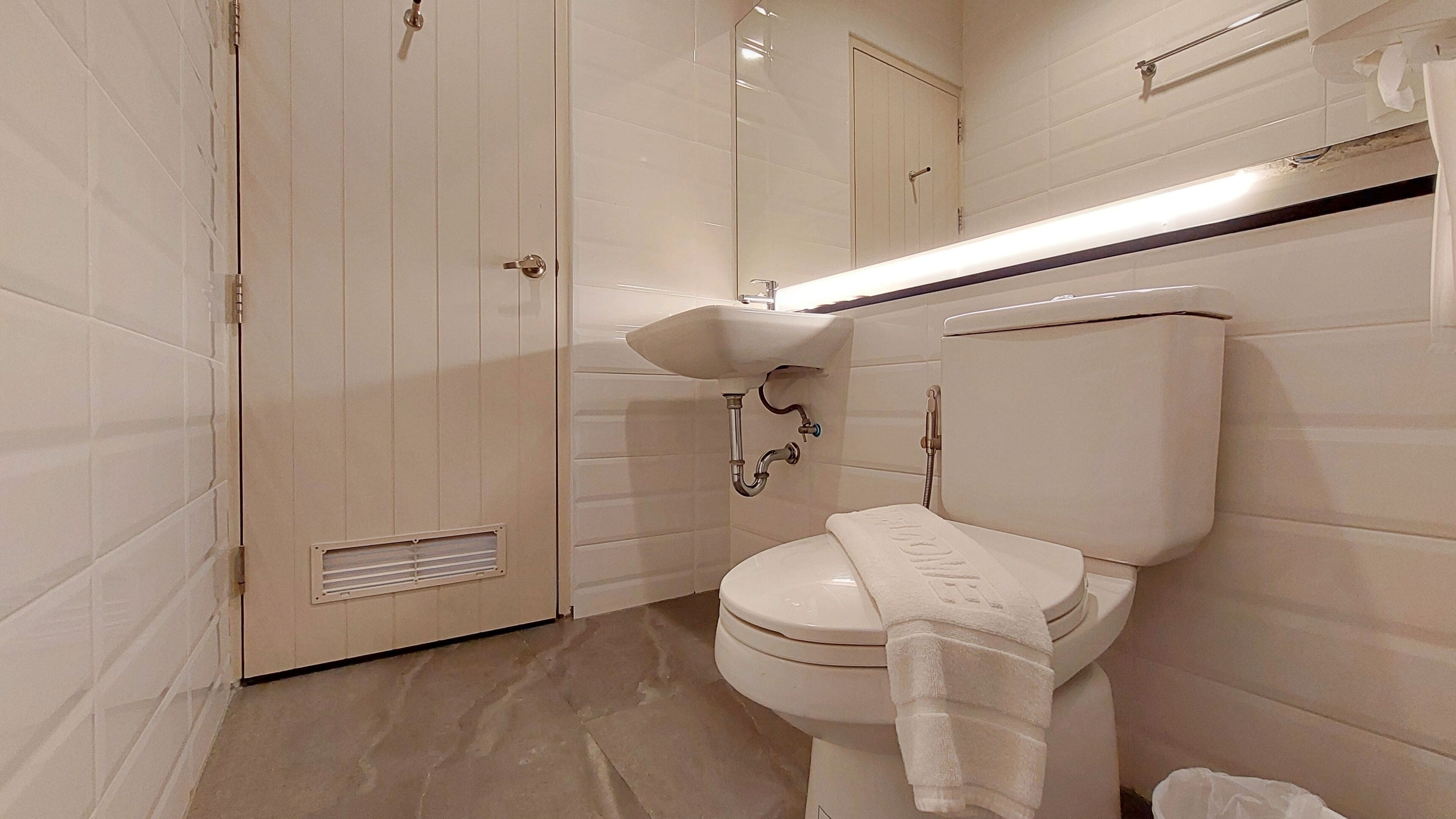 A bathroom with a toilet, sink, and shower.