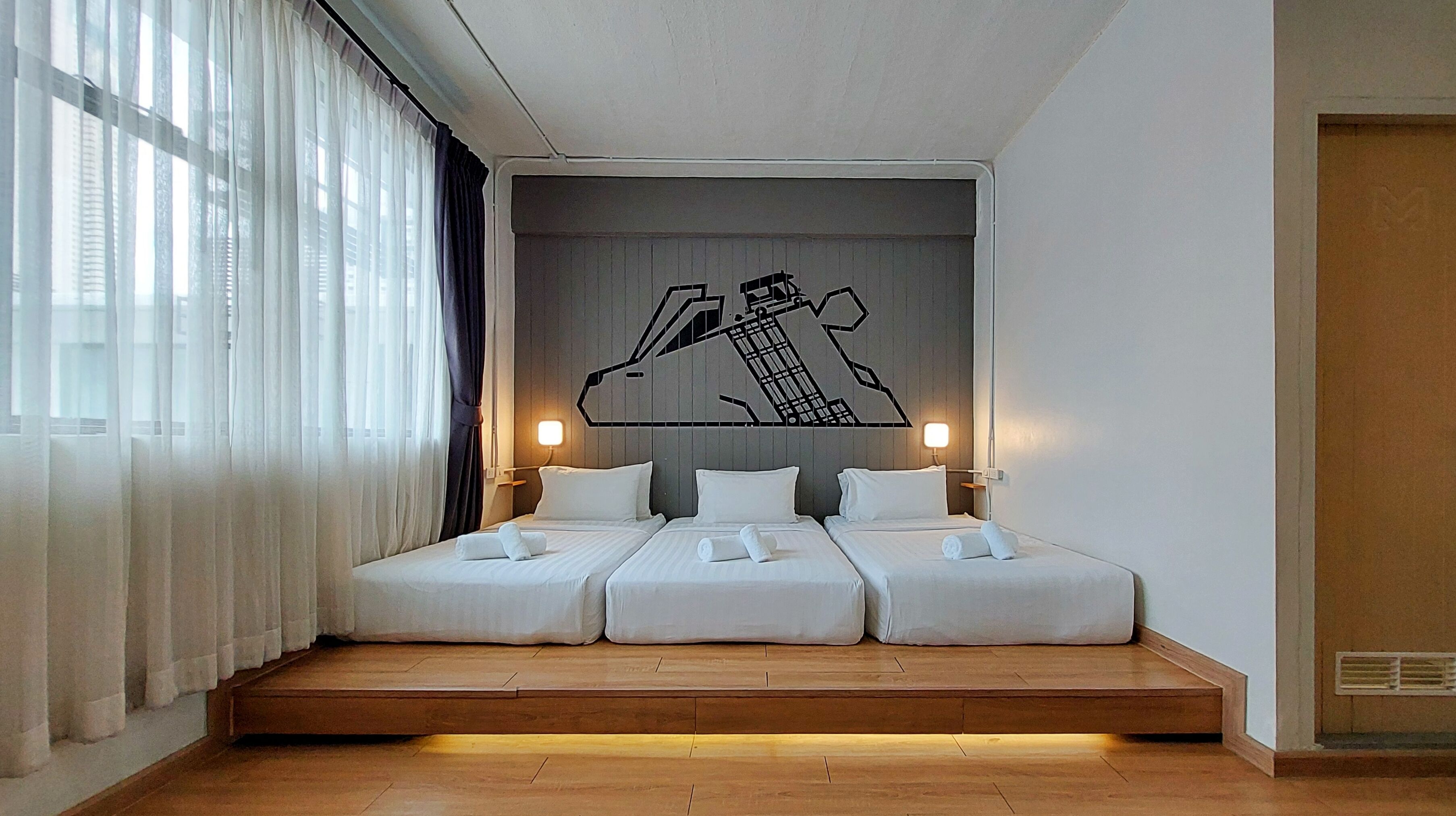 A hotel room with a bed, two bedside tables, and a wall-mounted artwork.