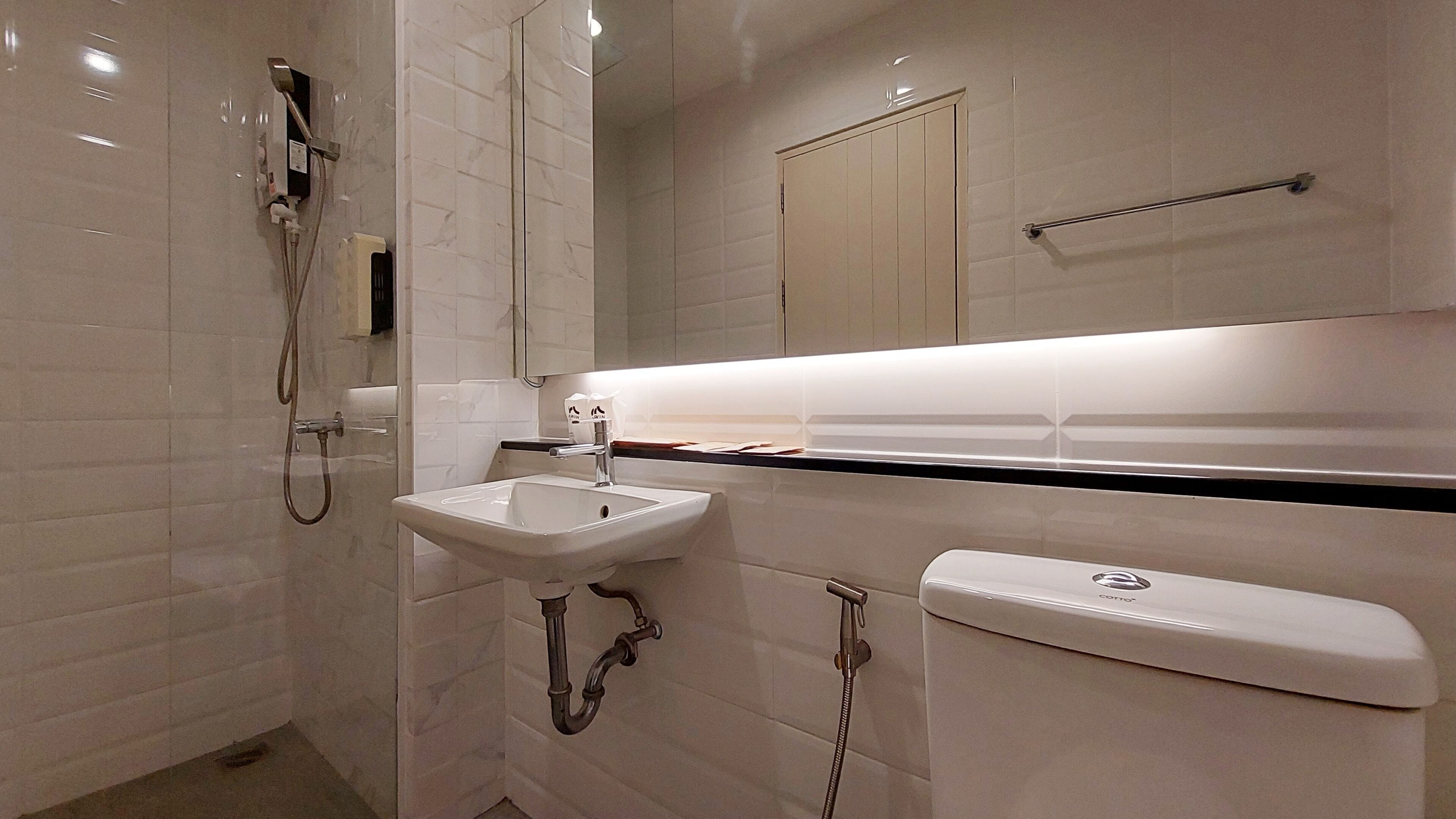 A bathroom with a sink, toilet, and shower.