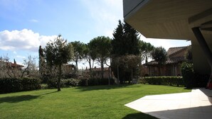 A well-maintained lawn with a paved walkway leading to a building entrance.