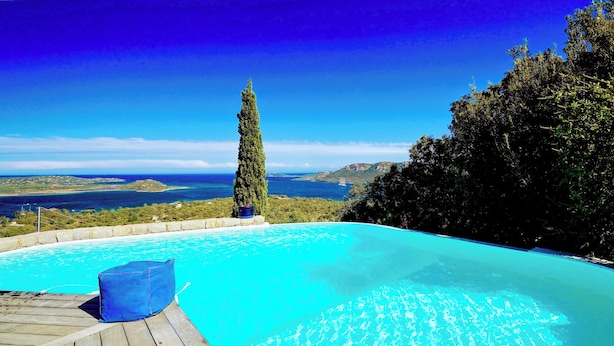 Una piscina infinita con vistas despejadas al mar y a la costa lejana.