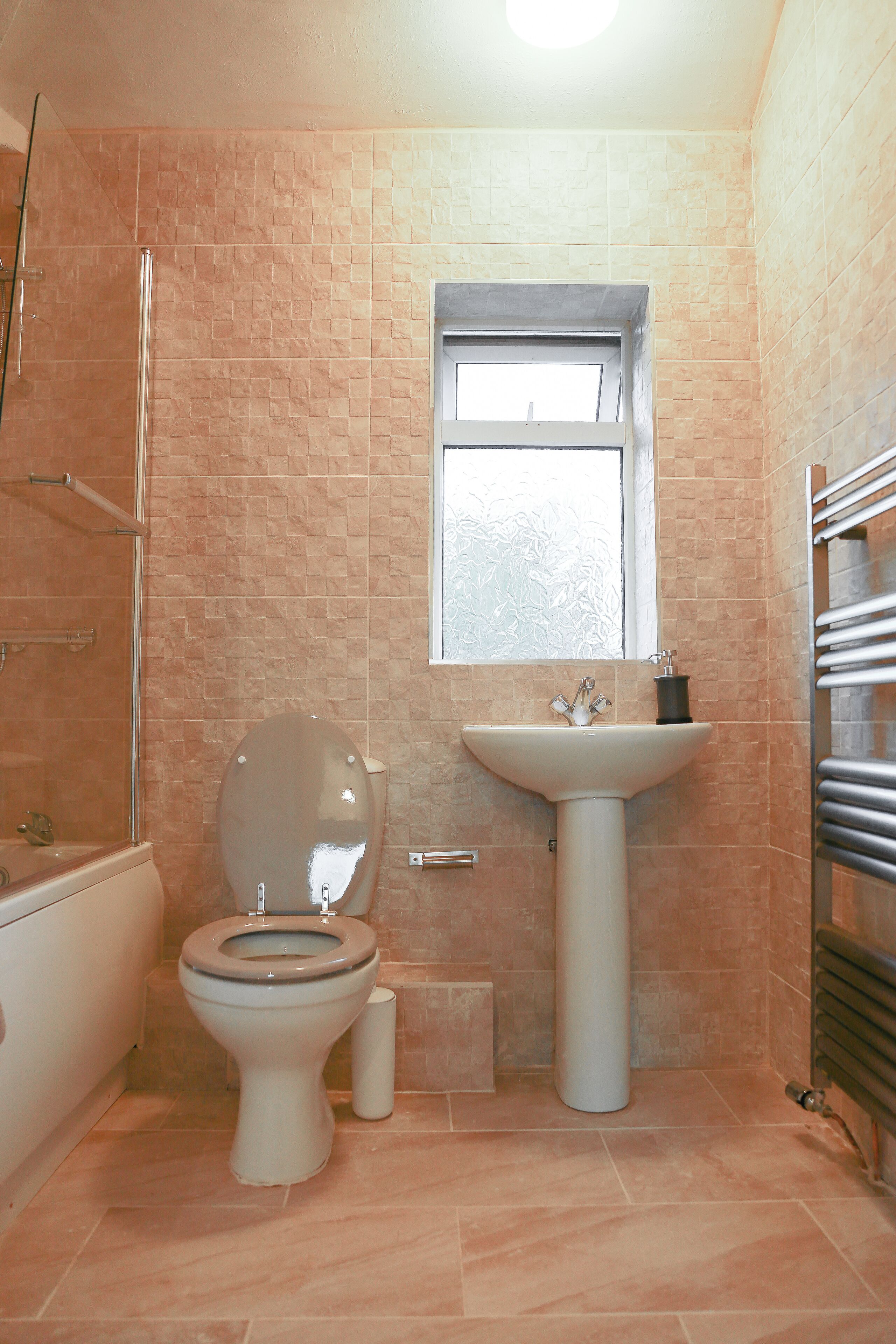 A bathroom with a toilet, sink, and shower.