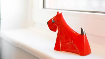 A red horse-shaped object on a white ledge by a window.
