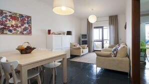 A modern apartment with a dining area, a living room, and a kitchen.