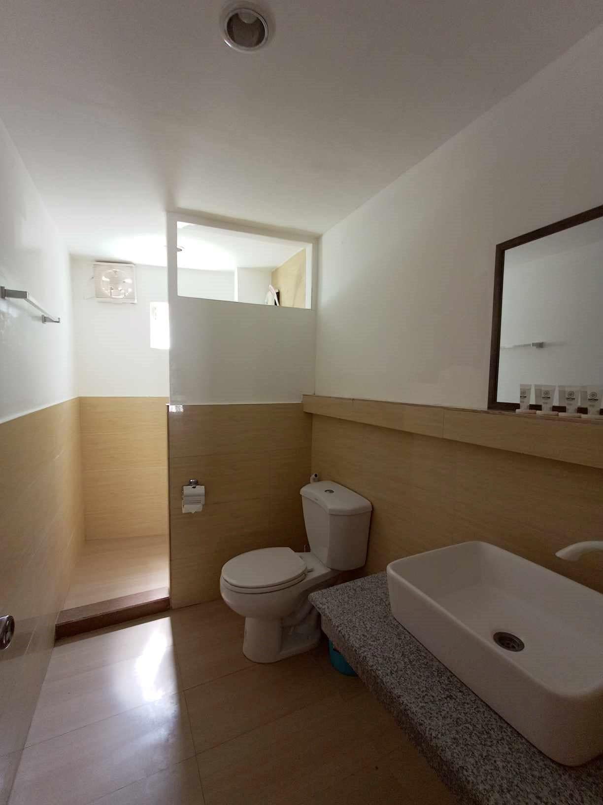 Ein Badezimmer mit Toilette, Waschbecken und Duschbereich.