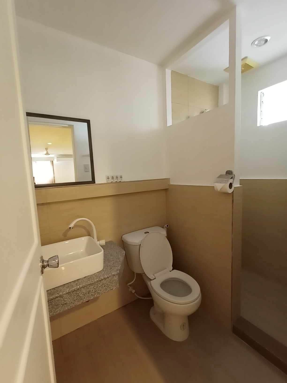 Un baño pequeño con inodoro, lavamanos y espejo.