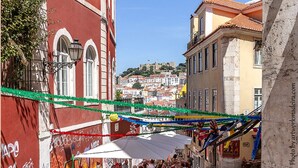 Une rue pavée avec des tables en terrasse et une vue sur une colline au loin.
