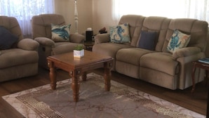 A living room with two sofas, a coffee table, and a patterned rug. - Jean's Cosy Sunny Cottage Sanctuary Point NSW Close to Palm Beach.
Netflix.  (Sanctuary Point)