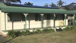 A single-story building with a green roof and a covered porch. - Jean's Cosy Sunny Cottage Sanctuary Point NSW Close to Palm Beach.
Netflix.  (Sanctuary Point)